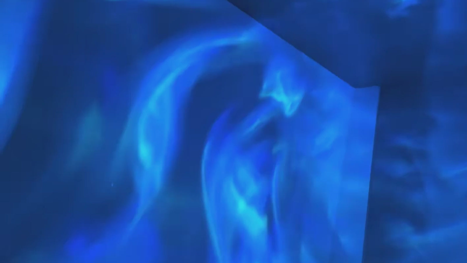 Light waves moving slowly across a wall in the dark, shifting between colours